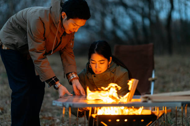 istock Friends preparing camping stove and making fire with firewood 1290091541