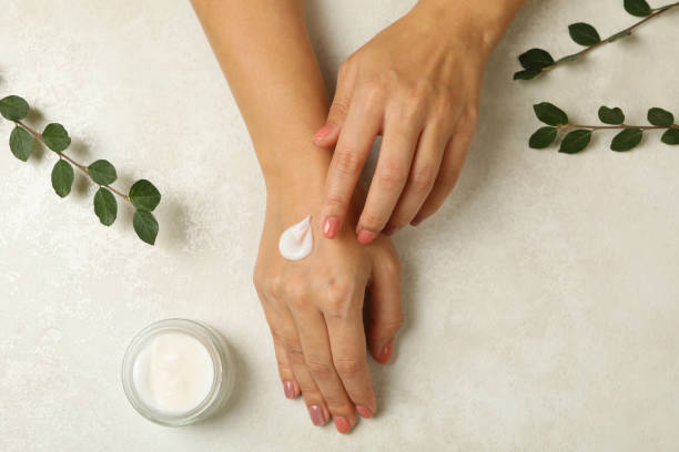 istock Female hands with cosmetics cream on white background 1290092203