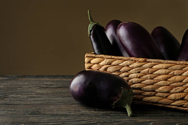 istock Fresh eggplants on wooden background 1290092985