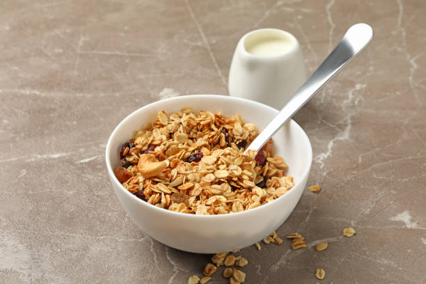 istock Bowl with granola and milk on gray background 1290095239