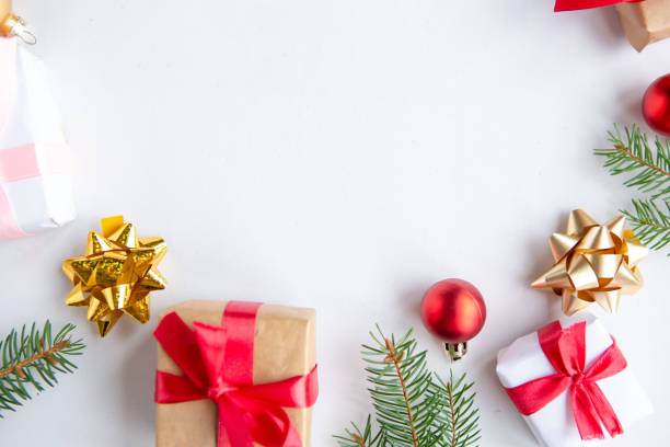 istock Christmas background with fir tree, present box and decorations at white background, top view, copy space for the text 1290095379