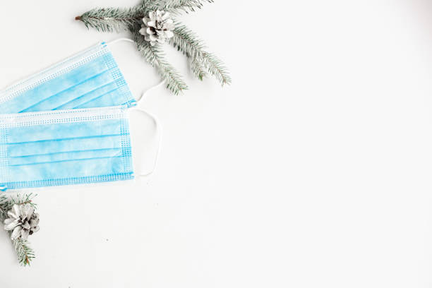 istock Face masks and spruce branches on white background, copy space for the text. Coronavirus Christmas concept 1290095381