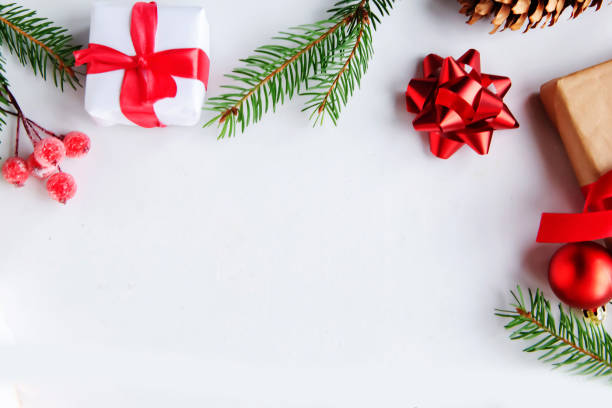 istock Christmas background with fir tree, present box and decorations at white background, top view, copy space for the text 1290095419