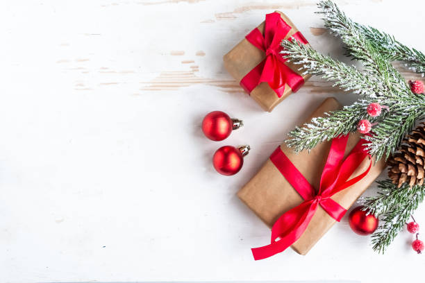 istock Christmas background with fir tree, present box and decorations at white table, top view 1290095492