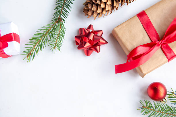 istock Christmas background with fir tree, present box and decorations at white background, top view, copy space for the text 1290095507