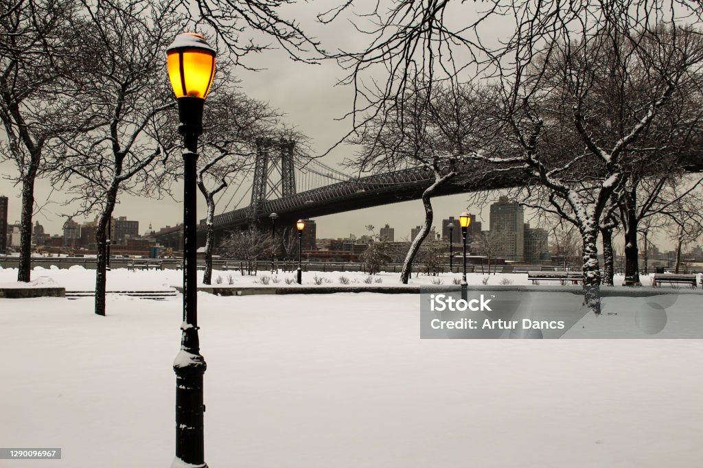 East River Park Promenade in the winter Evening walk in the East River Park at the Williamsburg Bridge by night after snow fall Night Stock Photo
