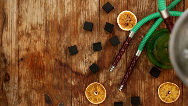 istock Coals for hookah on wooden background with dry oranges 1290097672