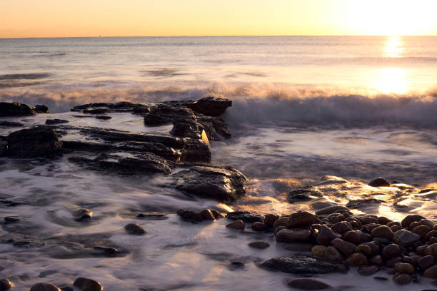istock Sunrise on the rocky beach 1290097901