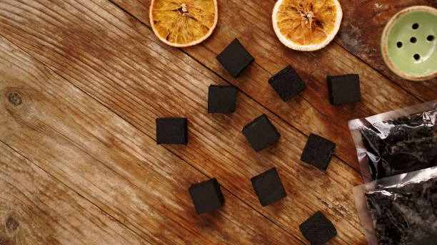 istock Coals for hookah on wooden background with dry oranges 1290097957