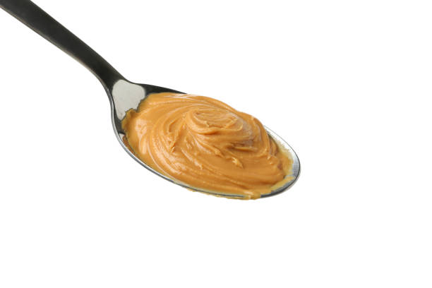 istock Spoon with peanut butter isolated on white background 1290098250