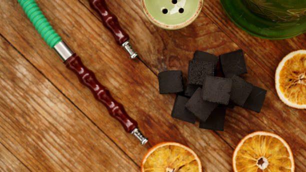 istock Coals for hookah on wooden background with dry oranges 1290098938