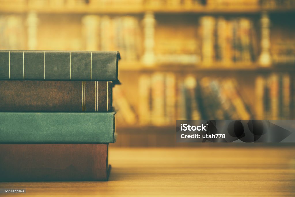 Stack of old books Stack of old books on wood table with library background. Education, books concept. Old Book Stock Photo