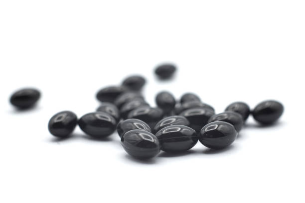 istock black pills of coal on white background 1290099334