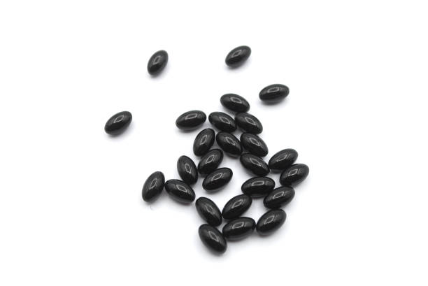 istock black pills of coal on white background 1290099476