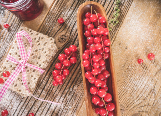 Red berries  with toast on wooden plate at retro concept.