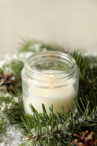 istock Scented candle, pine branches and snow, close up 1290100630