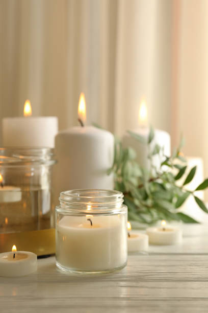 istock Burning scented candles for relax on white wooden table 1290100711