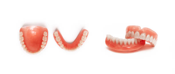 Full removable plastic denture of the jaws. Set of dentures on a white background. Two acrylic dentures. Upper and lower jaws with fake teeth. Dentures or false teeth, close-up. Copy space dentadura de plástico desmontable completa de las mandíbulas. conjunto de dentaduras postizas sobre un fondo blanco. dos prótesis acrílicas. mandíbulas superiores e inferiores con dientes falsos. dentaduras postizas o dientes falsos, primer plano. cop