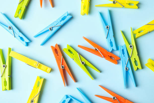 istock Color clothespins on blue background, top view 1290102013