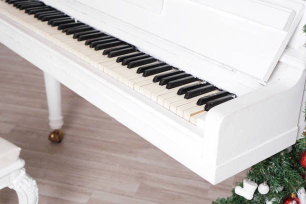 istock Keys on white upright piano with christmas decor 1290102316