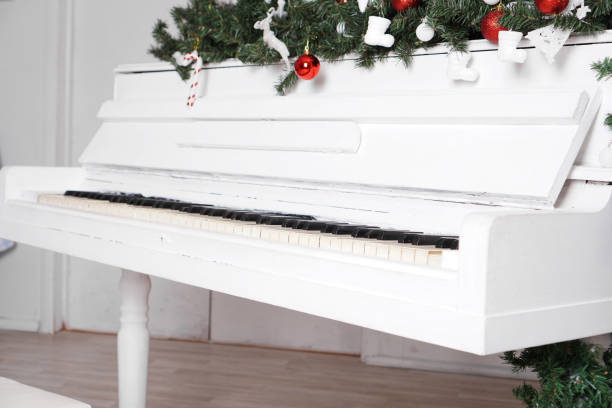 istock Keys on white upright piano with christmas decor 1290102831