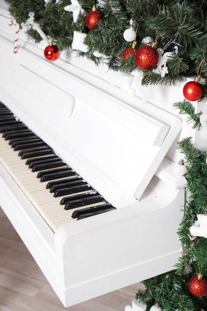 istock Keys on white upright piano with christmas decor 1290102857