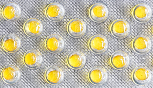 istock Small yellow round pills in silver bluster, macro 1290103737