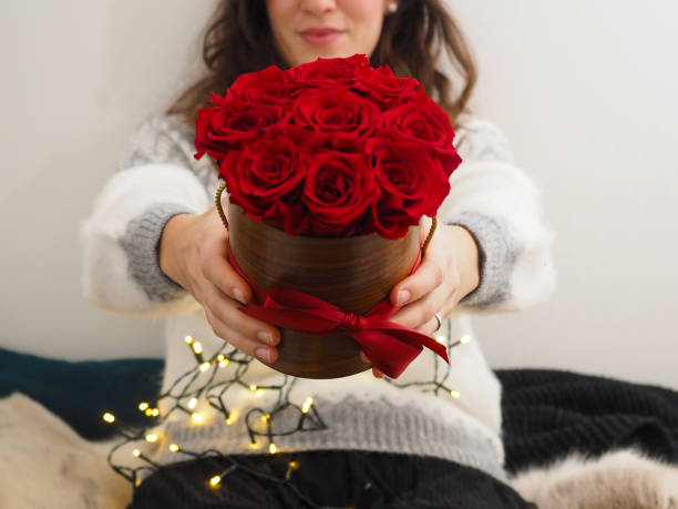 istock Young woman holding beautiful red roses bouquet 1290104921