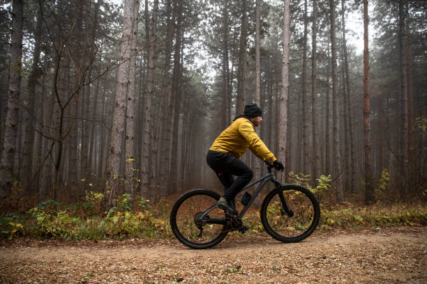 istock Young man biking through autumn forest 1290105276