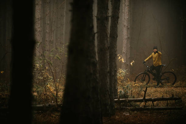 istock Young man taking a brake during biking through autumn forest 1290105280