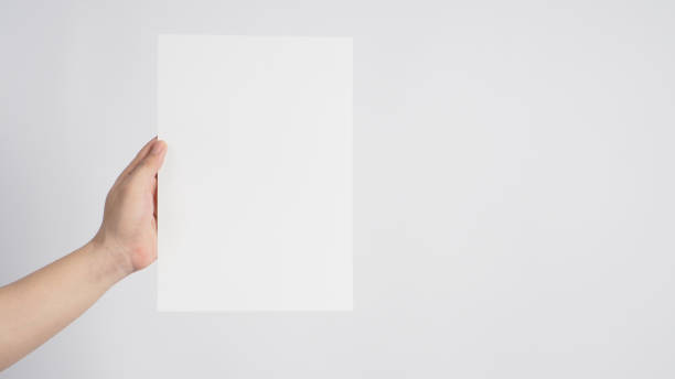 istock Hand is holding the blank A4 paper on white background. 1290105453