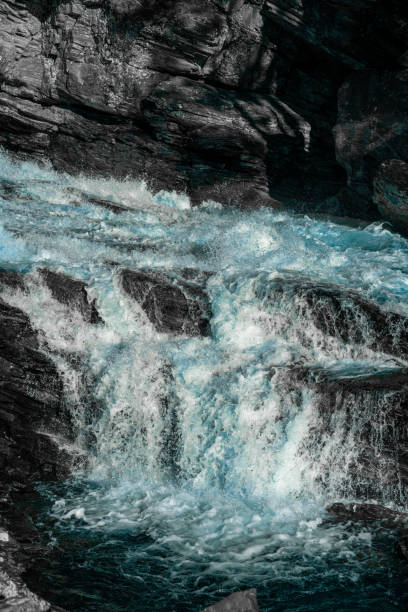 istock Wild and fast moving river rapids white water rushing over rugged cliffs. Close up. 1290105625