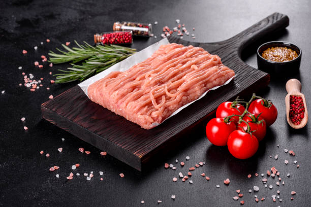 istock Fresh raw chicken mince on a dark wooden cutting board 1290106279