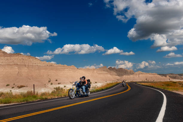 Badlands National Park, South Dakota - August 9, 2014: Bikers riding their chopper motorcycles on a dirt road at the Badlands National Park.