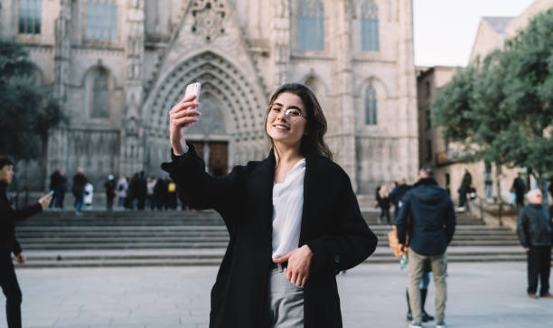 istock Delighted woman taking selfie on old square 1290106574