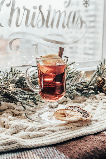 Winter grog with orange and cinnamon on a background of New Year's décor