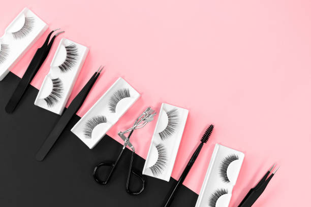 istock Various tools for eye lash extensions on a trendy pastel pink and black background. Banner. Concept. Eyelash curler, tweezers, brushes. Makeup accessories. Cosmetics. Fake eyelashes. Place for text. 1290107554