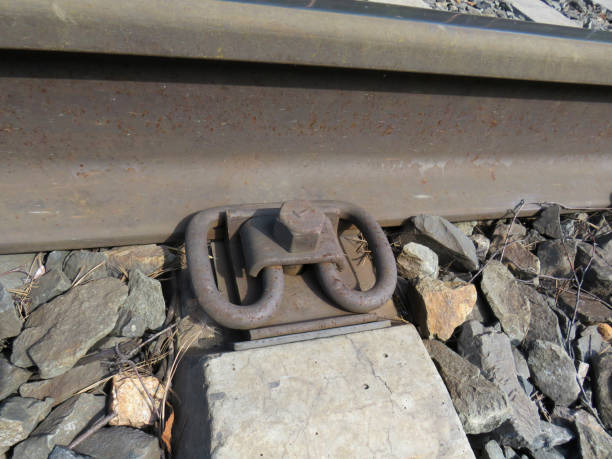 Bolted metal fastening of railway steel rails to concrete sleeper Bolted metal fastening of railway steel rails to concrete sleeper, close-up, industry, transport, industry, technology railroad track concrete railway sleeper thoroughfare stock pictures, royalty-free photos & images