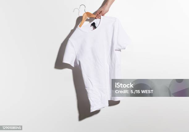 Hand Holds A White Crumple Tshirt On Wooden Hangers On A Gray Background  Stock Photo - Download Image Now - iStock