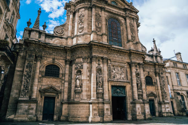From below of aged catholic church with ornaments of Gothic architecture located near square in city center of Bordeaux during cloudy day in France