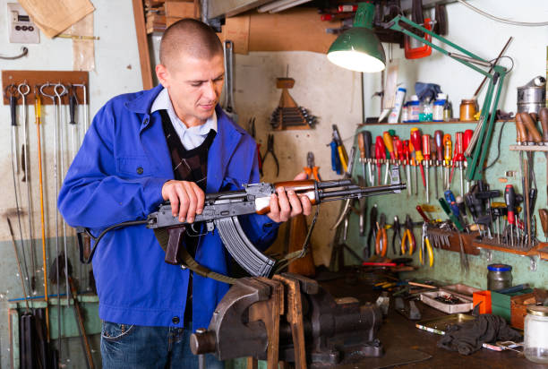 istock Gunsmith performing maintenance of Kalashnikov assault rifle in workshop 1290109278