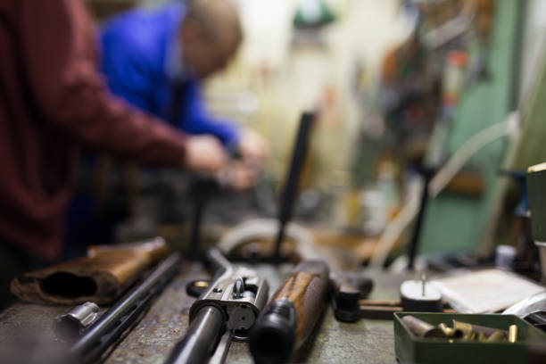 Disassembled shotgun on worktable of gunsmith in weapons workshop Closeup of disassembled shotgun during repair or maintenance on worktable of gunsmith in professional weapons workshop. Selective focus on gun weapon photos stock pictures, royalty-free photos & images