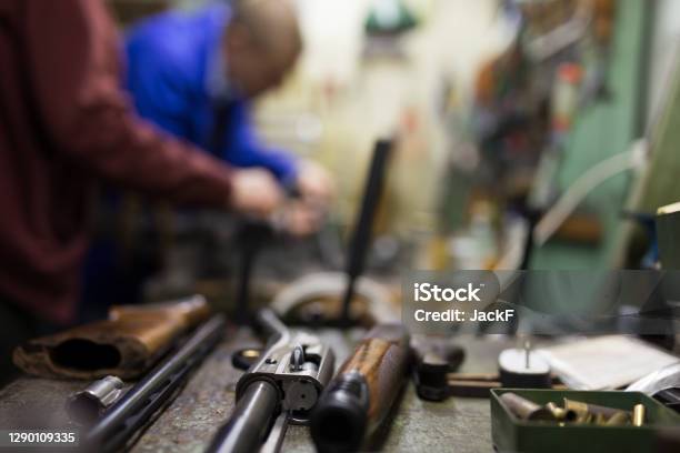 Disassembled Shotgun On Worktable Of Gunsmith In Weapons Workshop Stock Photo - Download Image Now