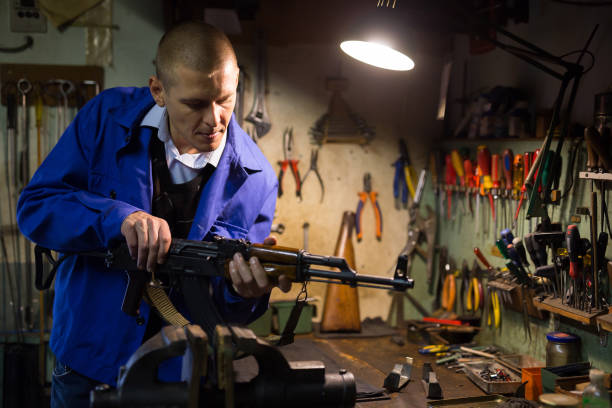 istock Gunsmith performing maintenance of Kalashnikov assault rifle in workshop 1290109355