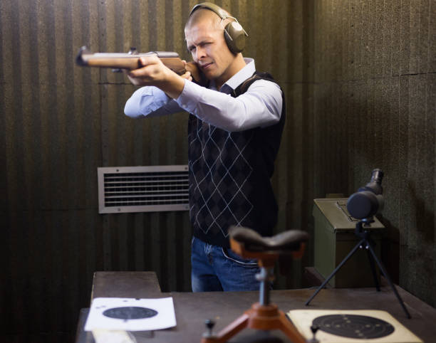 istock Man aims at a target with a semi-automatic rifle in shooting range 1290109362