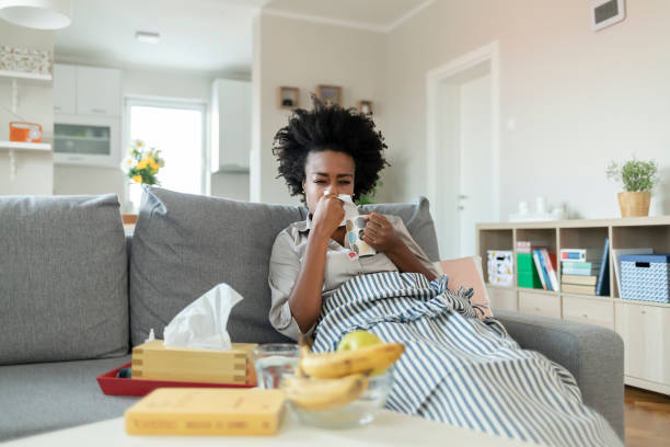 istock Sick young woman blowing her nose 1290113170