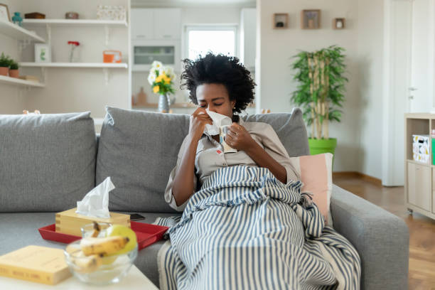 istock Sick young woman blowing her nose 1290113189
