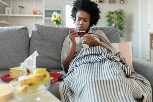 istock Woman Reading Her Temperature on a Thermometer at Home 1290113215