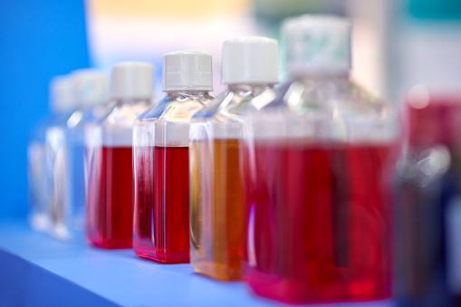 Close-up of red reagent bottles in a row.