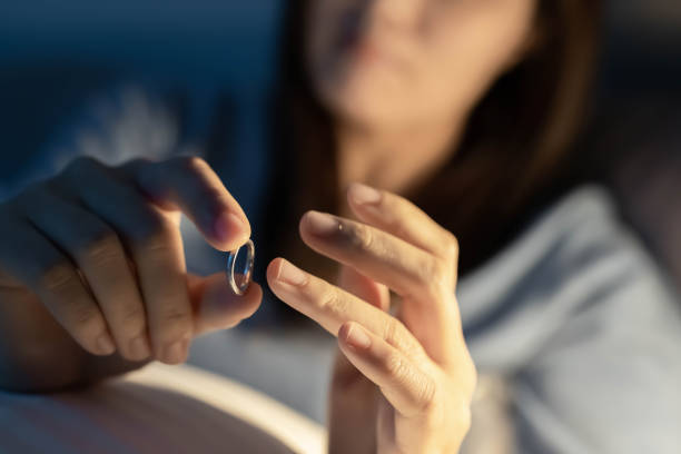 mujer deprimida celebrar anillo de boda - divorcio fotografías e imágenes de stock